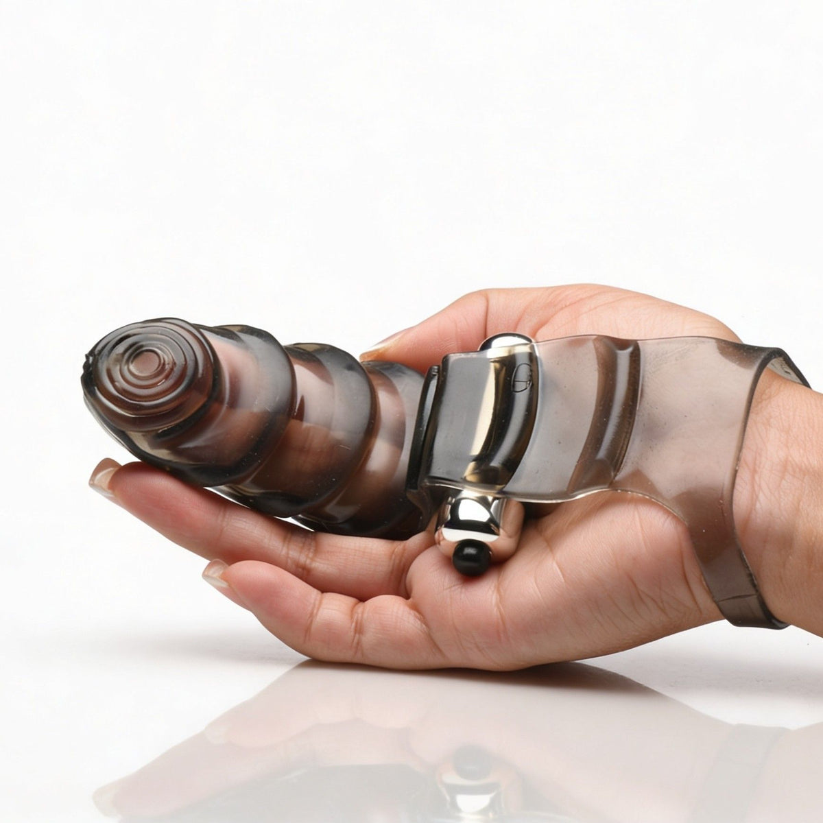 Hand holding the smoke-tinted vibrating finger glove to demonstrate the size, shape, and flexible textured design.