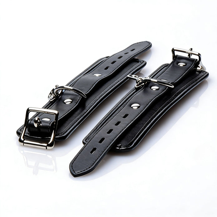 Close-up of a padded restraint cuff featuring adjustable sizing, secure buckle closure, and durable metal attachment hardware