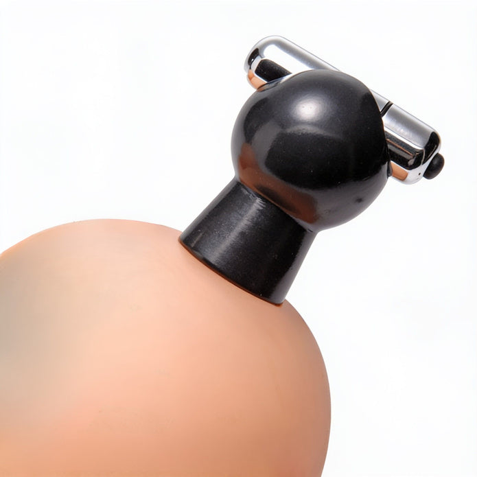 Black vibrating nipple sucker attached to a breast-shaped display, demonstrating how the suction cup fits and stays in place during use.