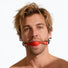 Male model wearing the silicone comfort ball gag featuring a smooth red silicone ball and adjustable black strap for a secure fit