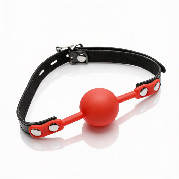 Silicone comfort ball gag featuring a bright red silicone ball, adjustable black faux leather strap, and secure metal buckle for a customizable fit