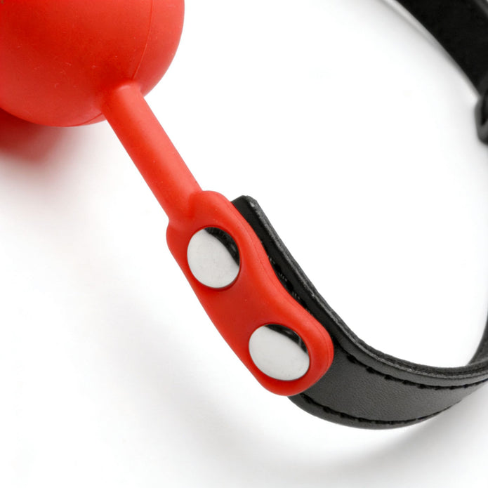 Detailed view of the silicone connector and metal rivets securing the red silicone ball to the adjustable black strap